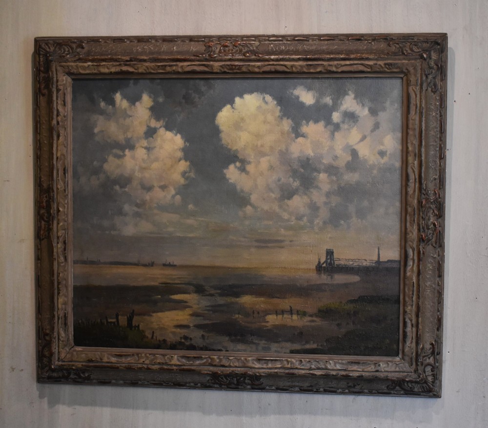 A framed oil painting on canvas depicting a coastal harbour scene at low tide under a cloudy sky.
