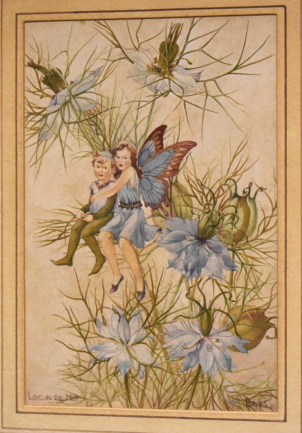 A framed watercolour illustration depicting two winged flower fairies sitting among blue love-in-the-mist blossoms, set within a double mount and a narrow gilt frame. View III