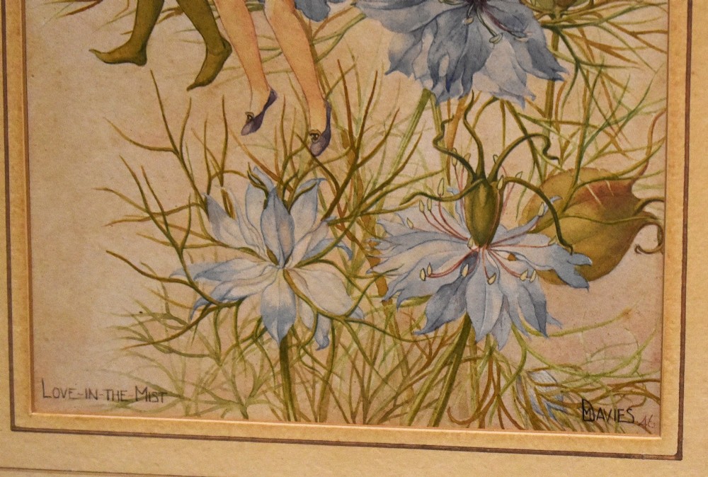 A framed watercolour illustration depicting two winged flower fairies sitting among blue love-in-the-mist blossoms, set within a double mount and a narrow gilt frame. View V