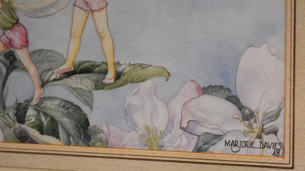 A framed watercolour painting titled Apple Blossom by Marjorie L Davies depicting two winged fairies and a bumblebee among apple blossoms. View V