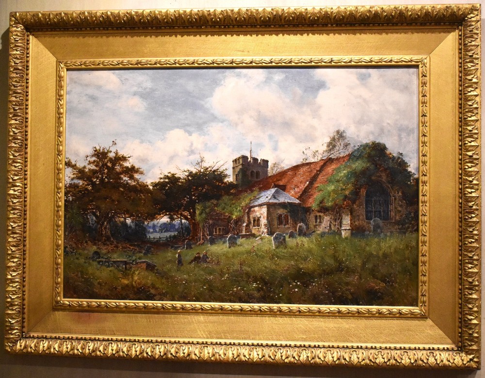 A Victorian landscape oil painting in an ornate gilded frame depicting a stone parish church and churchyard surrounded by trees under a cloudy sky. View II