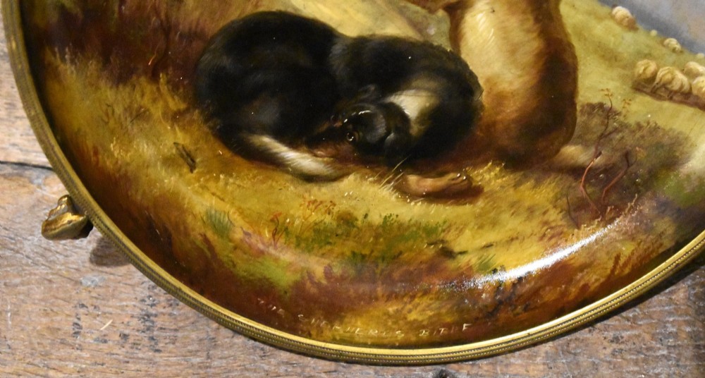 A circular Victorian papier mache comport featuring a hand-painted scene of dogs in a landscape, set within a gilt ormolu rim with decorative feet. View IV