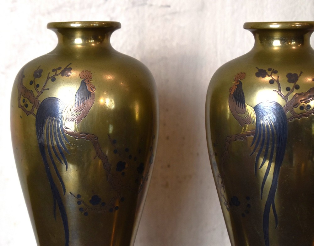 A pair of baluster-shaped golden bronze vases with detailed mixed-metal inlays depicting cockerels perched on branches, set on dark carved wooden bases. View II