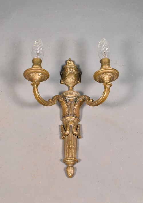 fig 1. A French Napoleon III style cast bronze wall sconce featuring two curved candle arms, a central urn finial, and a fluted backplate.
