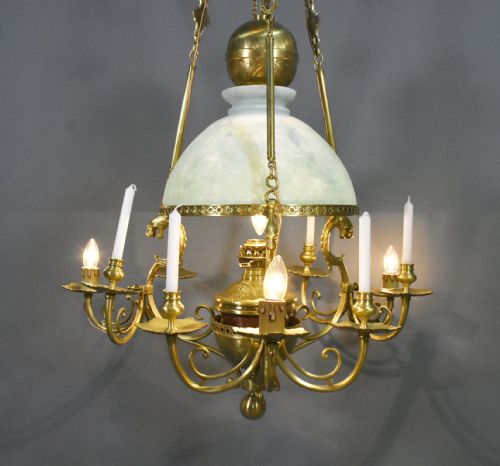 fig 2. A large French Napoleon III period bronze chandelier featuring a central domed opaline glass shade surrounded by multiple curved scroll arms with candle sconces.