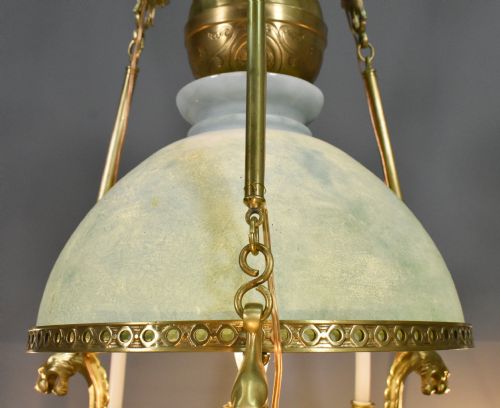 fig 4. A large French Napoleon III period bronze chandelier featuring a central domed opaline glass shade surrounded by multiple curved scroll arms with candle sconces.