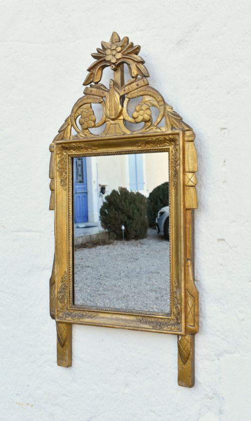 fig 2. A rectangular French giltwood wall mirror featuring carved floral cresting and a gold leaf frame.