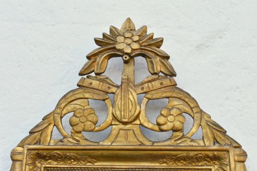 fig 3. A rectangular French giltwood wall mirror featuring carved floral cresting and a gold leaf frame.