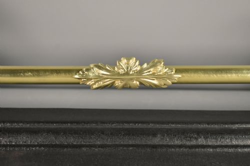 fig 4. A 19th-century French fireplace fender featuring dark patinated metal greyhound sculptures resting on bases on either side of a polished brass rail with central gold-toned foliate detailing.