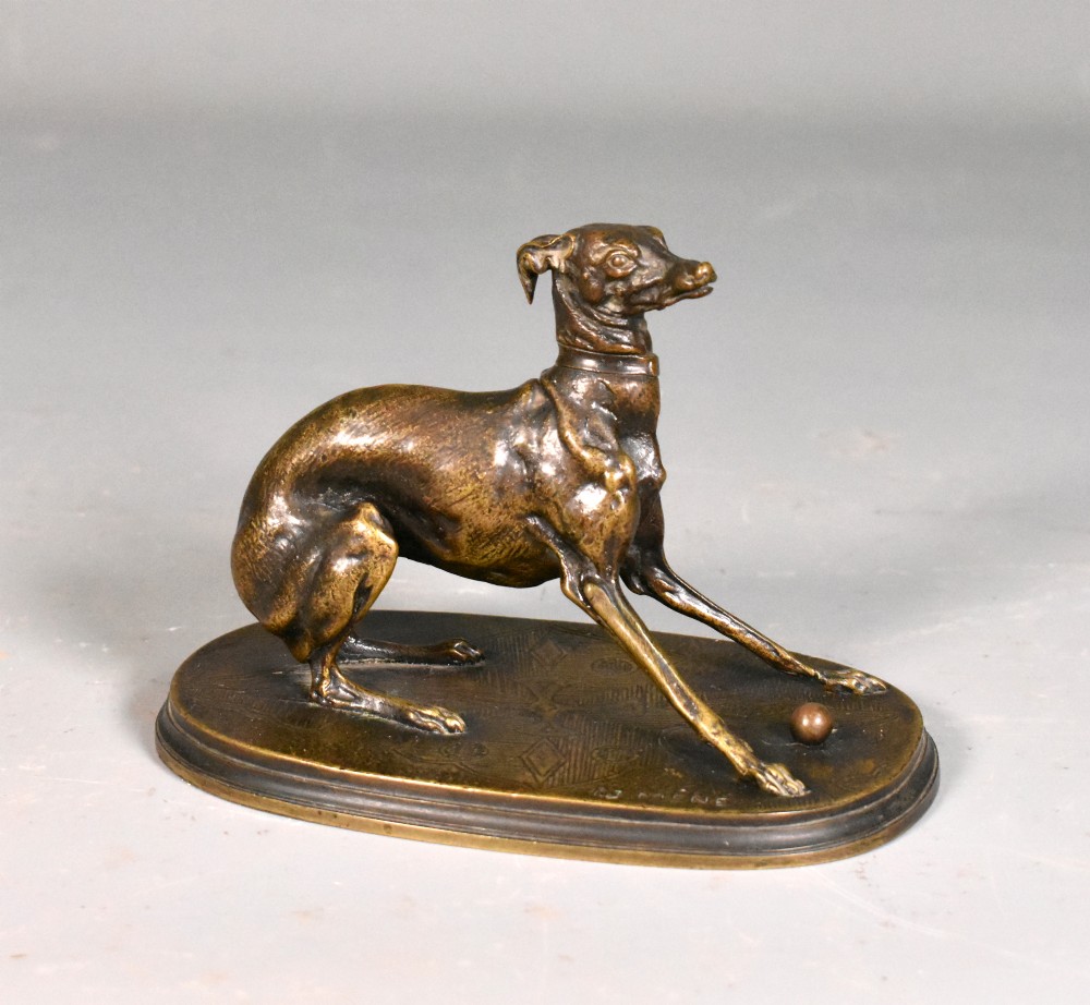 A 19th-century patinated bronze sculpture depicting a greyhound crouched near a ball on an oval base.