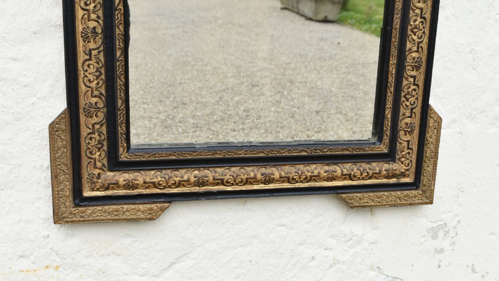 A rectangular Napoleon III wall mirror featuring a carved giltwood frame with black ebonised inner border and ornamental cresting. View VI