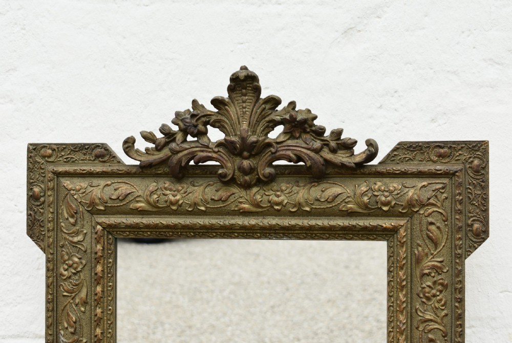 A rectangular antique French Napoleon III giltwood wall mirror with an ornate carved floral frame and top acanthus crest. View V