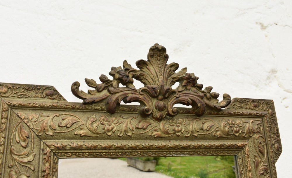 A rectangular antique French Napoleon III giltwood wall mirror with an ornate carved floral frame and top acanthus crest. View VI