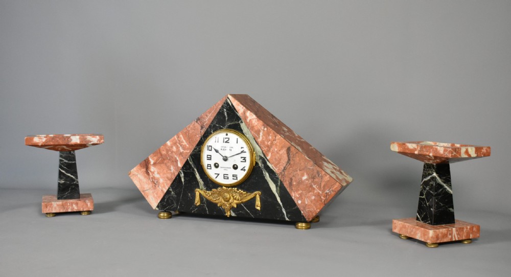 A French Art Deco three-piece clock set made from geometric pink and black veined marble with brass mounts. View III