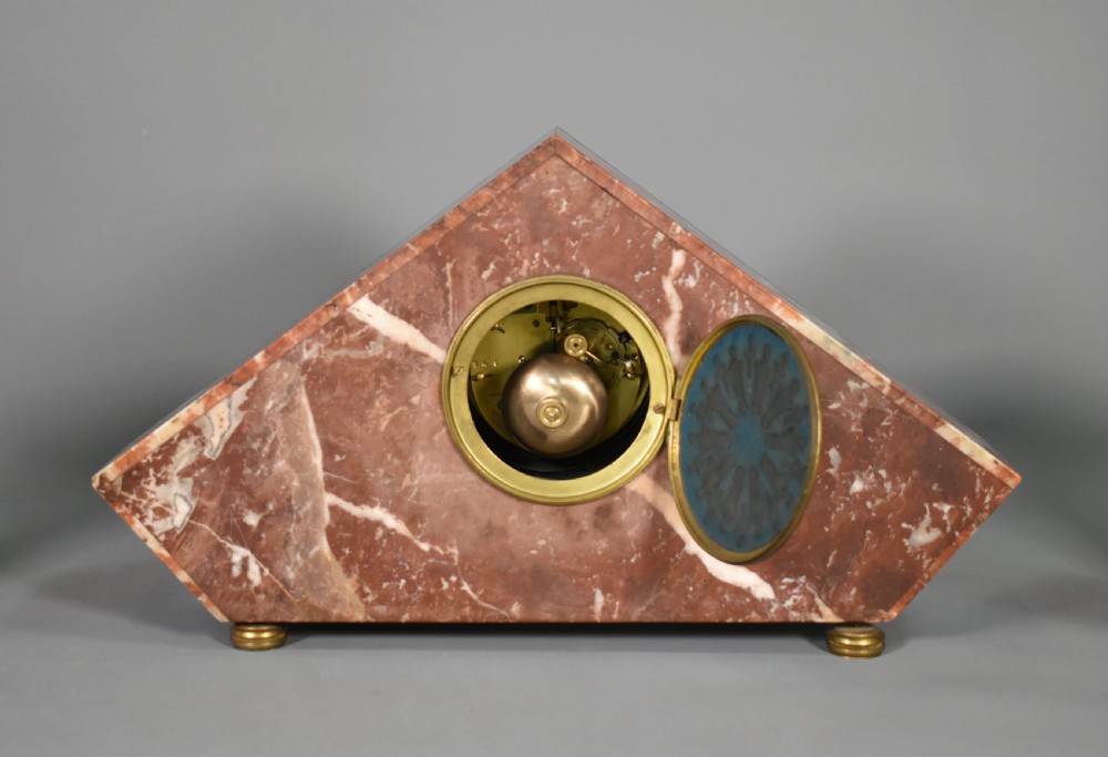 A French Art Deco three-piece clock set made from geometric pink and black veined marble with brass mounts. View XII
