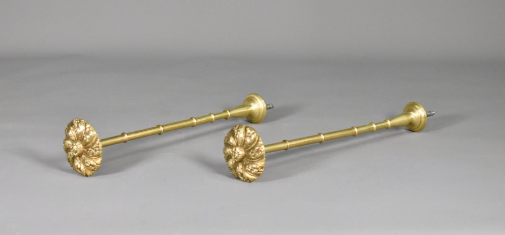 A pair of Second Empire French brass curtain tie-backs featuring circular carved floral rosettes on extended stems. View III
