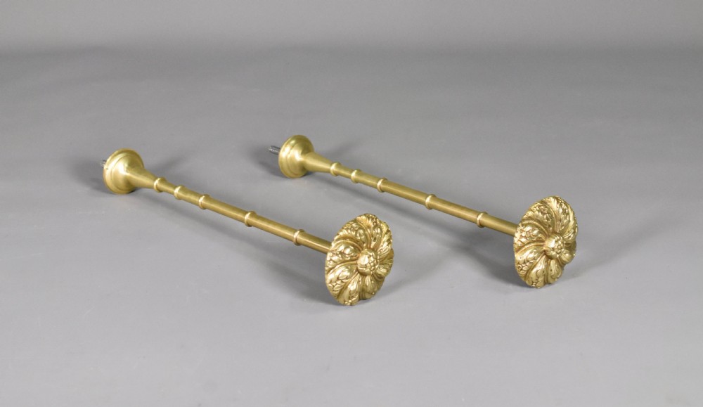 A pair of Second Empire French brass curtain tie-backs featuring circular carved floral rosettes on extended stems. View V