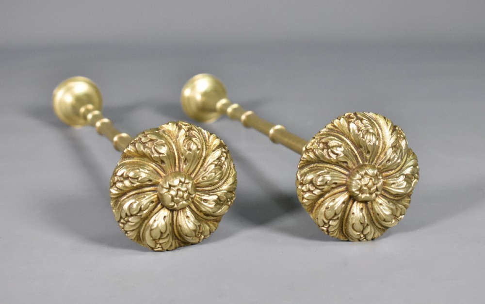 A pair of Second Empire French brass curtain tie-backs featuring circular carved floral rosettes on extended stems. View X