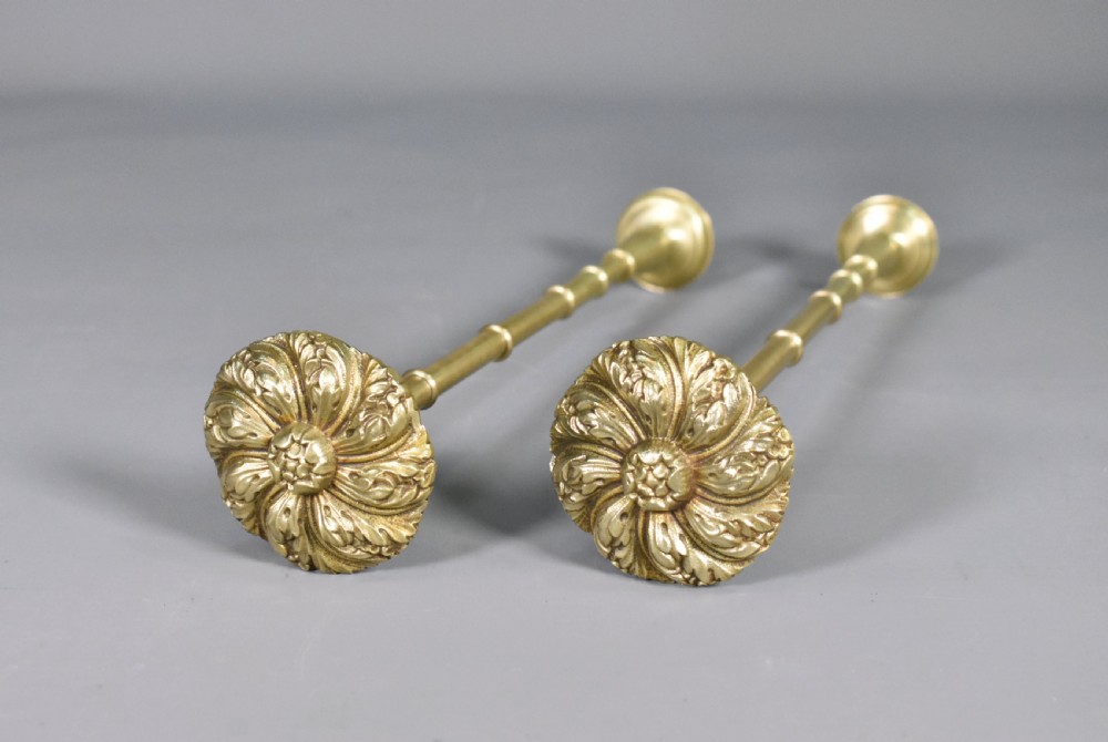 A pair of Second Empire French brass curtain tie-backs featuring circular carved floral rosettes on extended stems. View XI