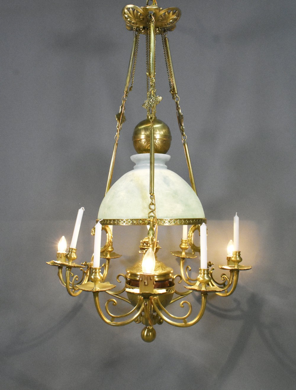 A large French Napoleon III period bronze chandelier featuring a central domed opaline glass shade surrounded by multiple curved scroll arms with candle sconces.