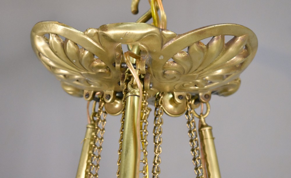 A large French Napoleon III period bronze chandelier featuring a central domed opaline glass shade surrounded by multiple curved scroll arms with candle sconces. View VIII