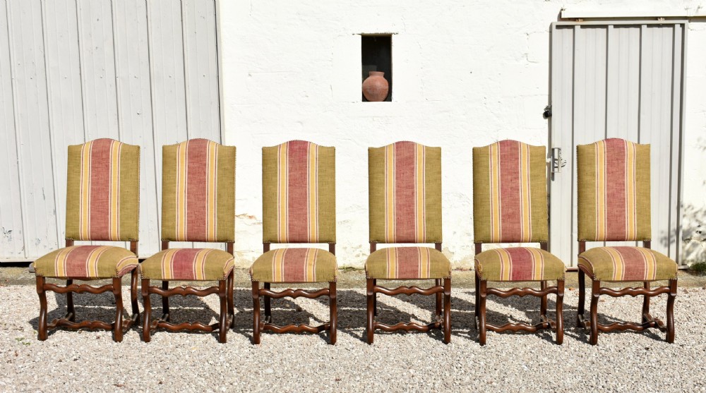 A set of six French Louis XIII style oak dining chairs featuring carved os de mouton legs and striped terracotta red and olive green upholstery.