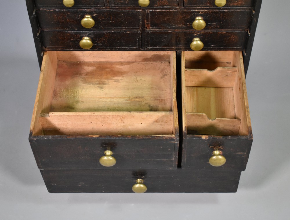 A tall dark wood antique horologist cabinet featuring multiple small drawers with brass knobs and a top compartment with a keyhole escutcheon. View XIV