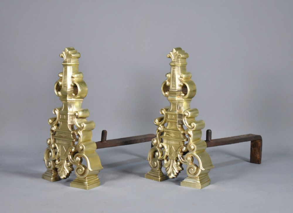 A pair of ornate cast brass French fire dogs featuring scrollwork, acanthus leaf details, and finial tops. View IV