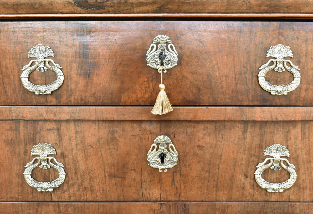 A 19th-century French Louis Philippe walnut commode featuring a rounded top drawer, three lower drawers with brass drop handles, and a plinth base. View VII