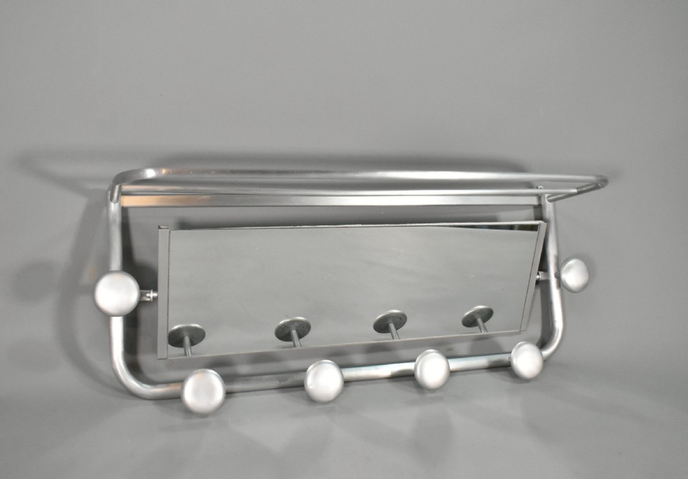 A French Art Deco wall-mounted tubular aluminium coat and hat rack featuring a central rectangular mirror, top slatted shelf, and spherical pegs. View II