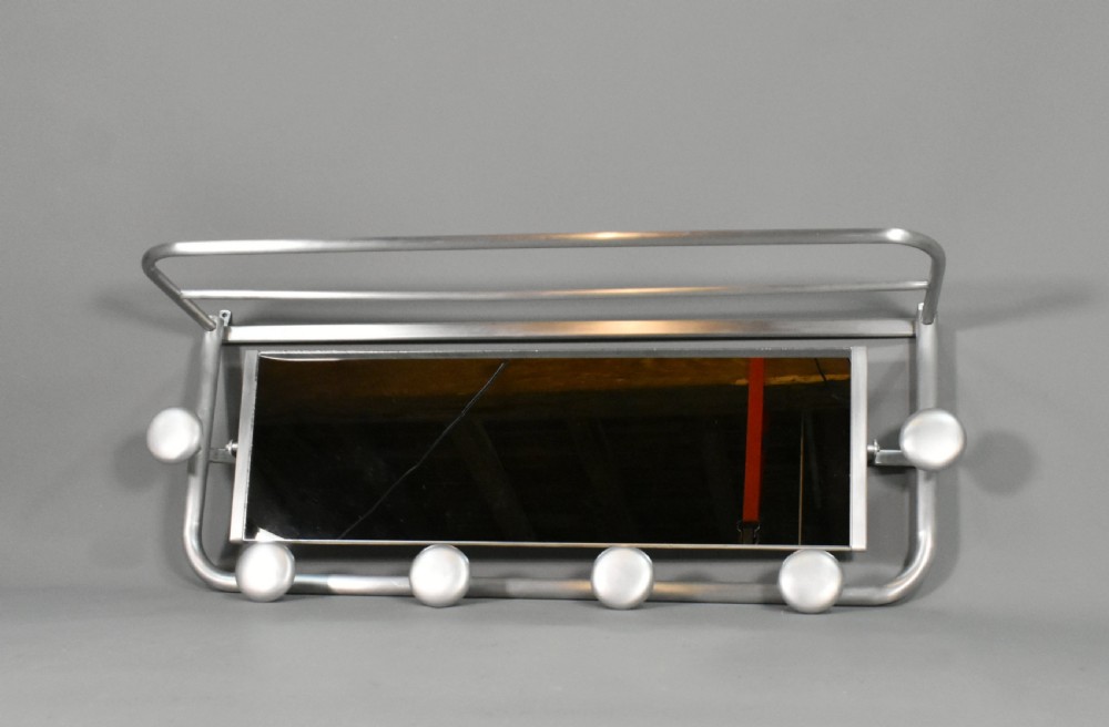 A French Art Deco wall-mounted tubular aluminium coat and hat rack featuring a central rectangular mirror, top slatted shelf, and spherical pegs. View VI