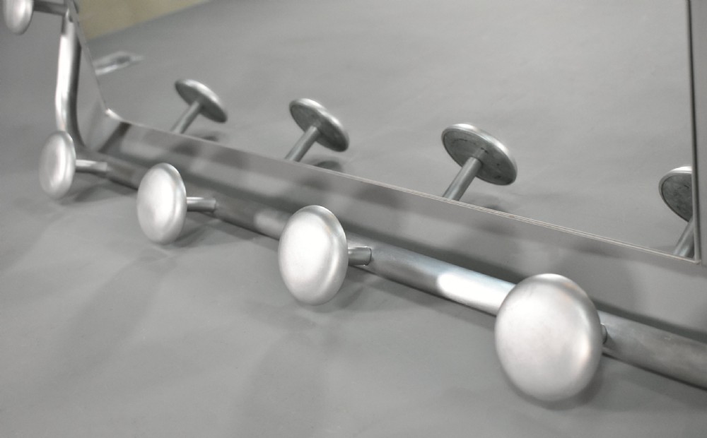 A French Art Deco wall-mounted tubular aluminium coat and hat rack featuring a central rectangular mirror, top slatted shelf, and spherical pegs. View X