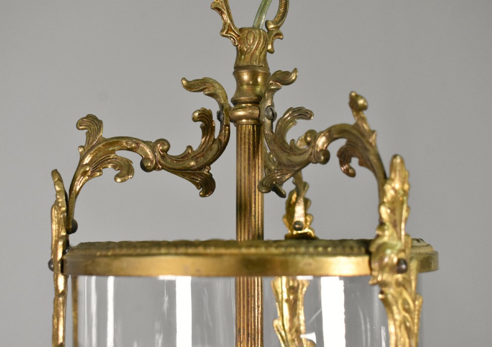 A cylindrical glass hall lantern featuring starburst engravings, gilt brass acanthus leaf mounts, and an interior multi-candle bulb holder. View VII