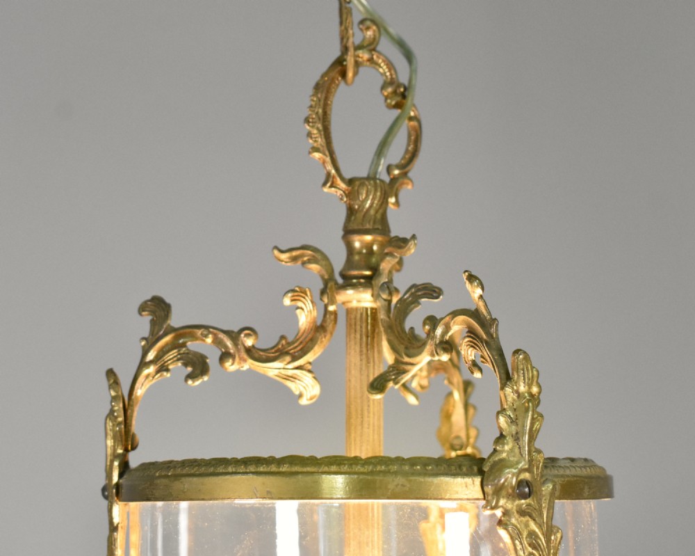 A cylindrical glass hall lantern featuring starburst engravings, gilt brass acanthus leaf mounts, and an interior multi-candle bulb holder. View VIII