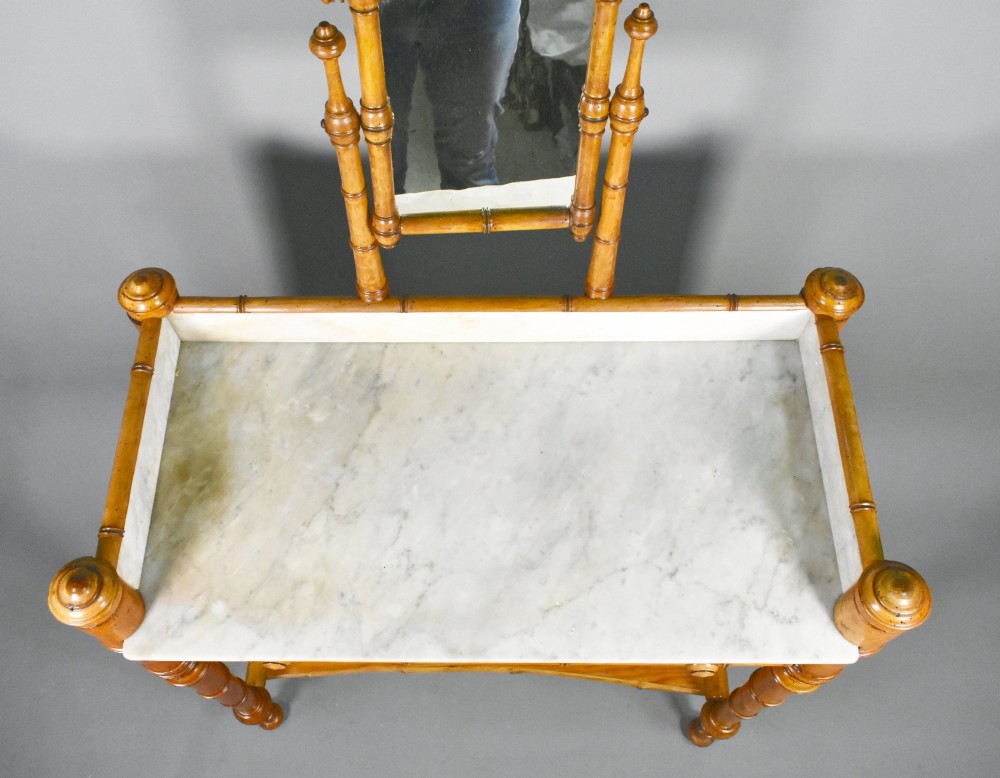An antique French Napoleon III style washstand with a turned pine faux bamboo frame, marble top, lower shelf, and attached tilting mirror. View V