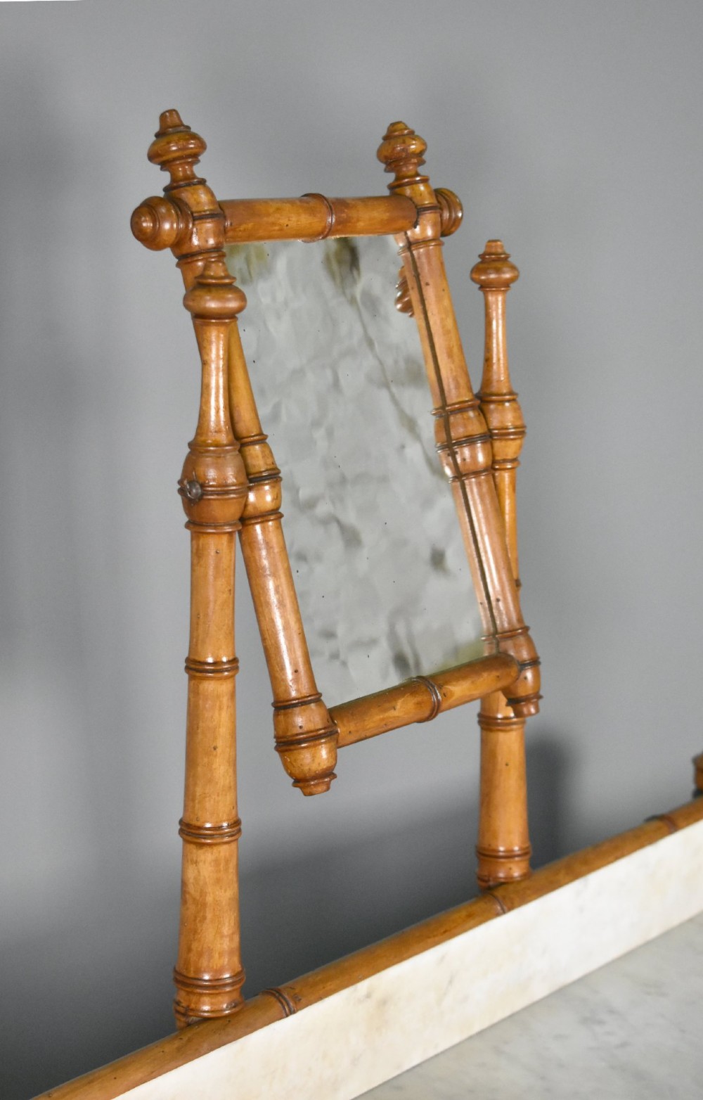 An antique French Napoleon III style washstand with a turned pine faux bamboo frame, marble top, lower shelf, and attached tilting mirror. View VII