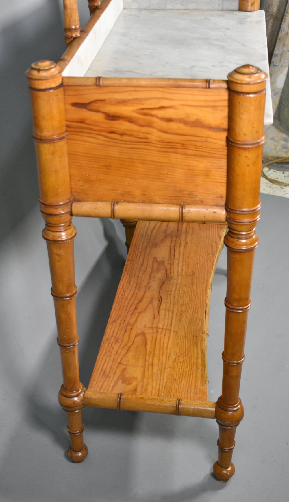 An antique French Napoleon III style washstand with a turned pine faux bamboo frame, marble top, lower shelf, and attached tilting mirror. View XI