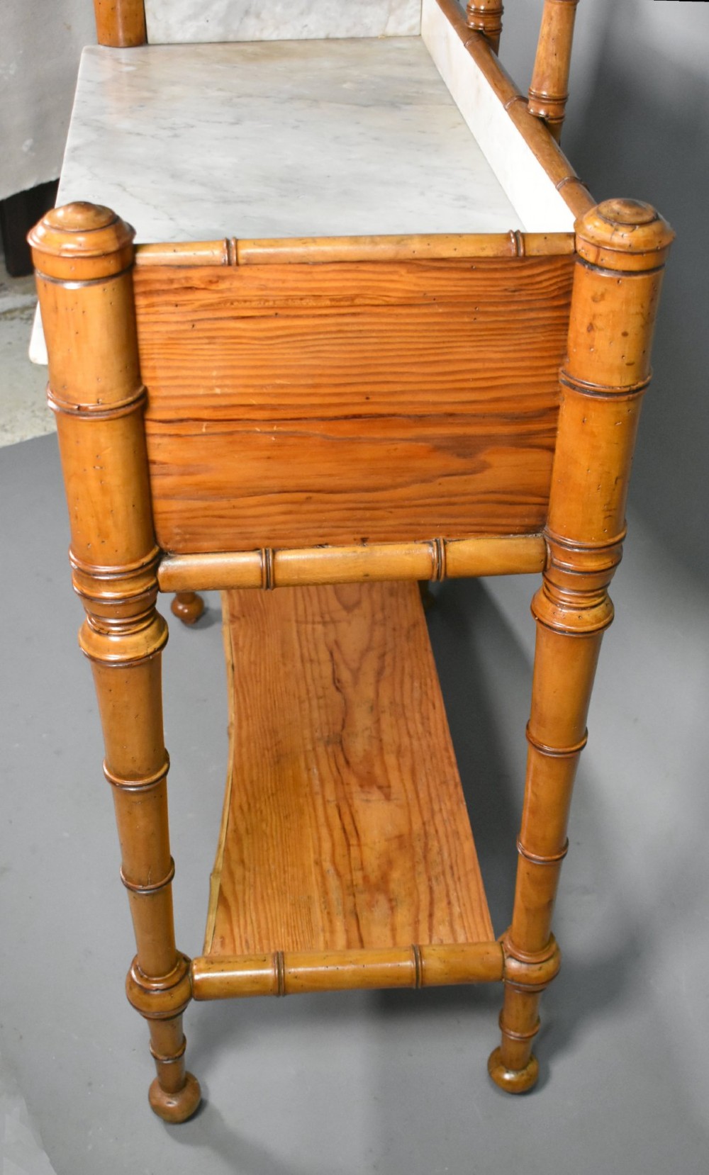An antique French Napoleon III style washstand with a turned pine faux bamboo frame, marble top, lower shelf, and attached tilting mirror. View XII