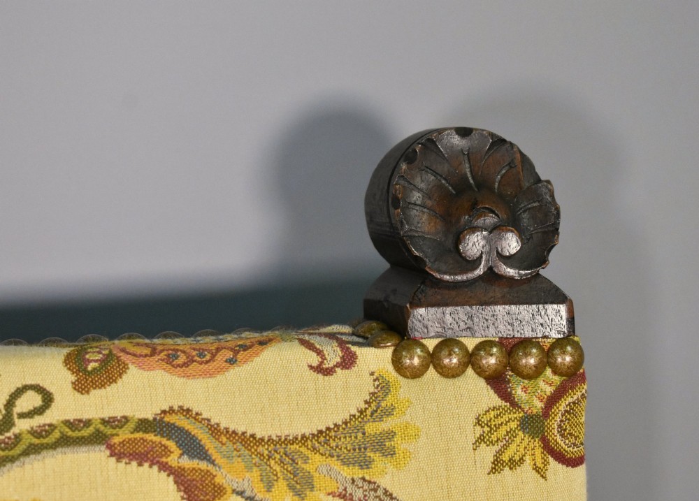A French Renaissance Revival walnut armchair featuring yellow floral upholstery, brass stud trim, turned legs, spherical armrests, and a spindle gallery backrest. View VIII