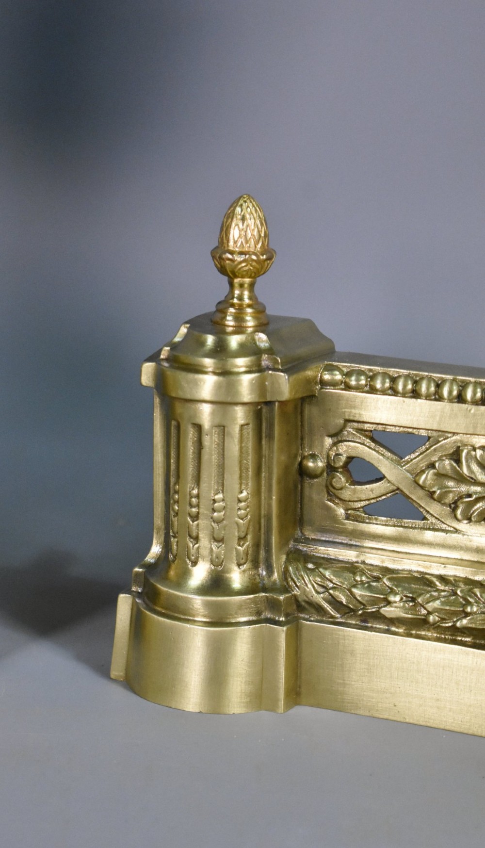 A pair of nineteenth-century French bronze fire dogs featuring carved urn finials, draped swags, and openwork bases. View VII