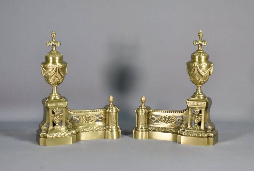 A pair of nineteenth-century French bronze fire dogs featuring carved urn finials, draped swags, and openwork bases. View VIII