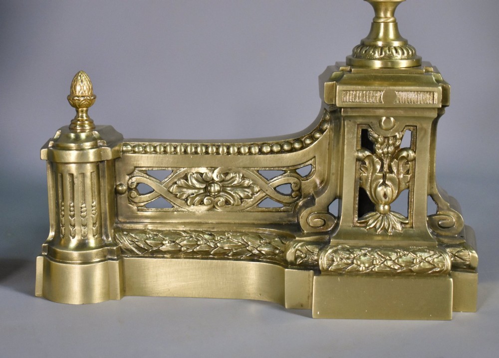 A pair of nineteenth-century French bronze fire dogs featuring carved urn finials, draped swags, and openwork bases. View XI