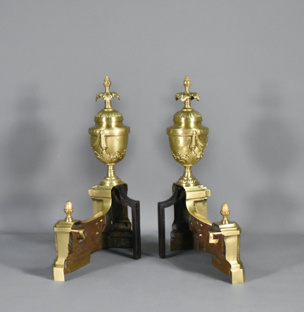 A pair of nineteenth-century French bronze fire dogs featuring carved urn finials, draped swags, and openwork bases. View XIII