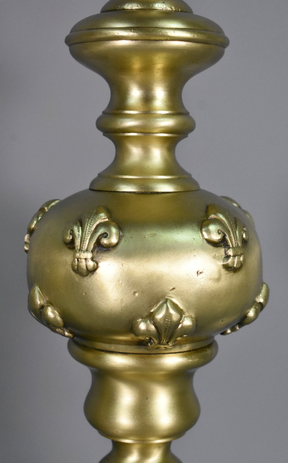 A pair of cast bronze Louis XIV style firedogs featuring baluster shafts, flame finials, and scrolled bases with relief mask carvings. View VIII