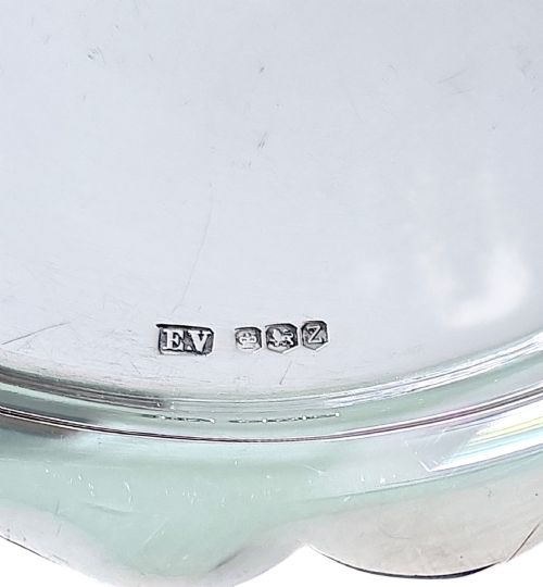 fig 2. A small sterling silver card tray featuring a scalloped border and stamped British hallmarks on the flat surface.