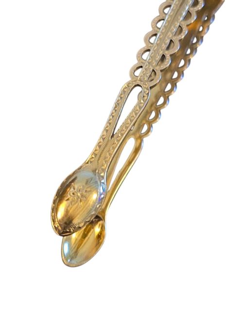 fig 1. A pair of Victorian silver-gilt sugar tongs featuring decorative pierced arms and engraved spoon-shaped ends.