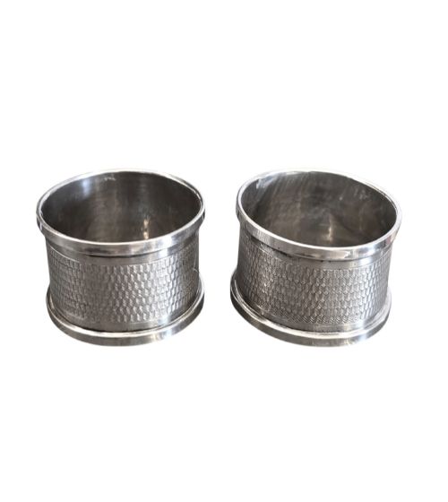 fig 1. A pair of oval sterling silver napkin rings featuring an engine-turned textured band and plain polished edges.
