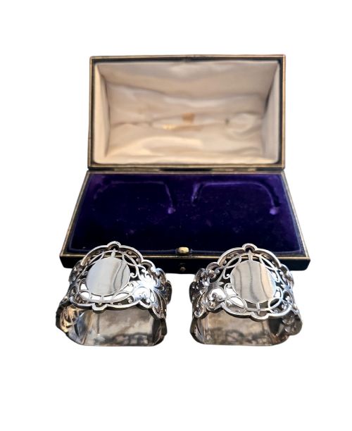 fig 1. A pair of Edwardian pierced sterling silver napkin rings with unengraved cartouches presented in a dark velvet-lined fitted box.