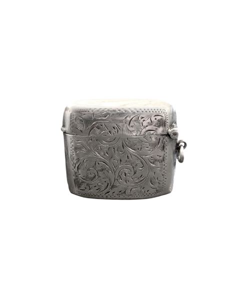 fig 1. A small rectangular sterling silver vesta case with hand-engraved scrollwork, a central vacant shield cartouche, and a side suspension ring.