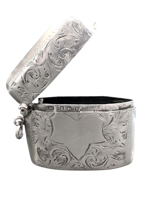 fig 3. A small rectangular sterling silver vesta case with hand-engraved scrollwork, a central vacant shield cartouche, and a side suspension ring.